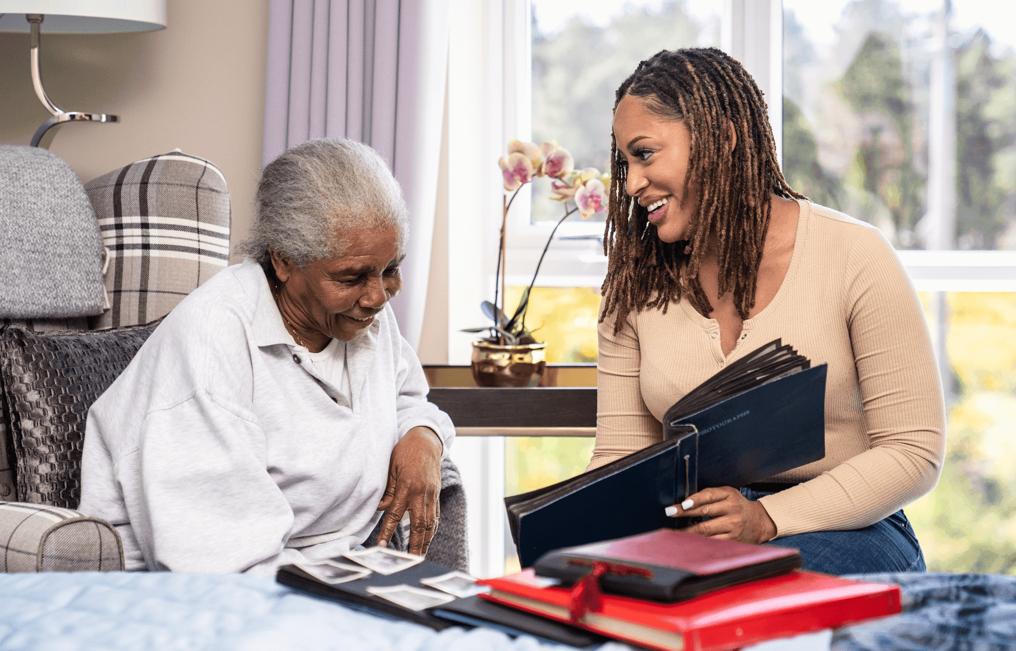 A resident and relative looking at old photos to help with dementia