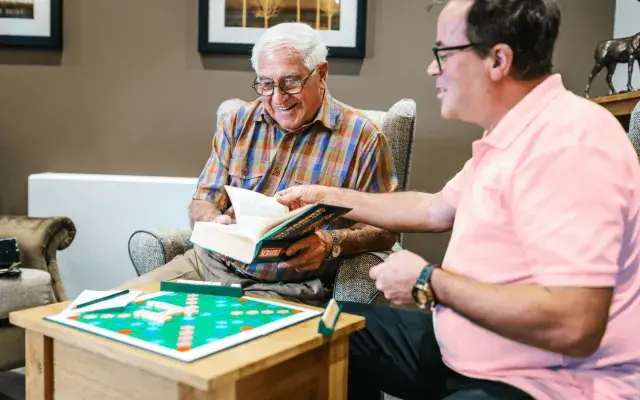 A nurse and a resident playing scrabble in a nursing care home